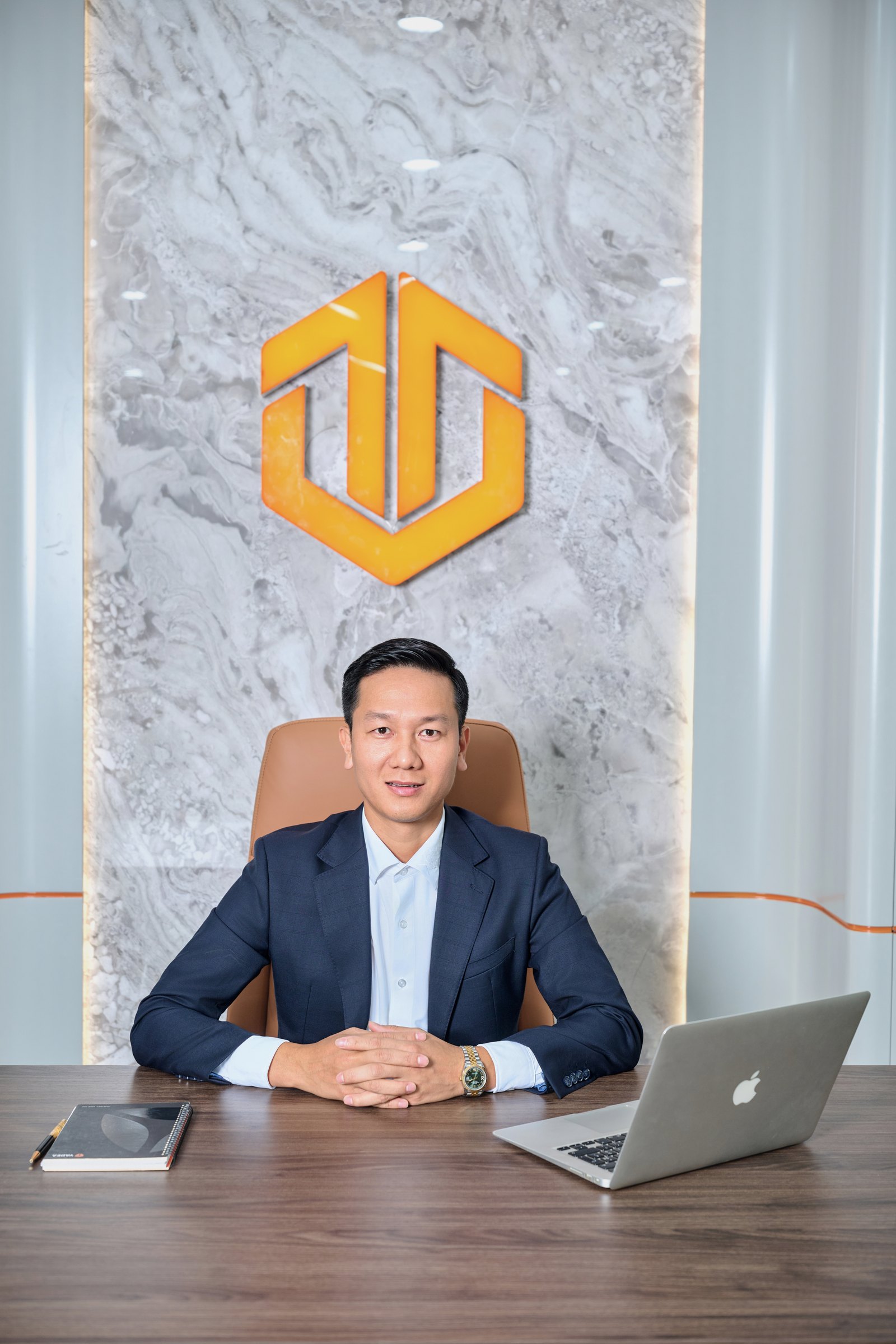Lê Hồng Thanh tại bàn làm việc, phía sau là biểu trưng Việt Thanh